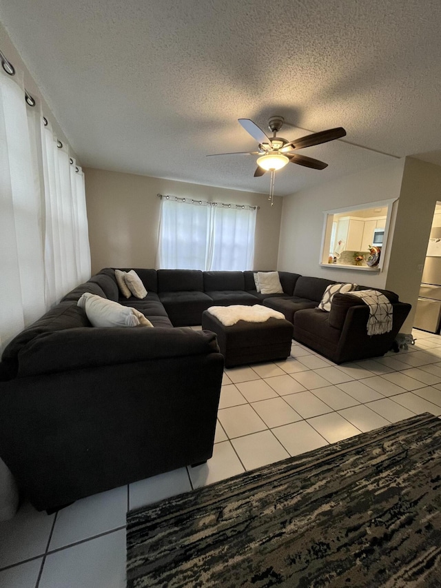 tiled living room featuring ceiling fan and a textured ceiling