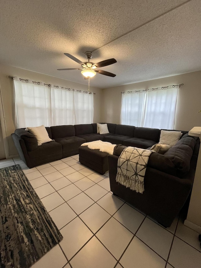 tiled living room featuring a textured ceiling and ceiling fan