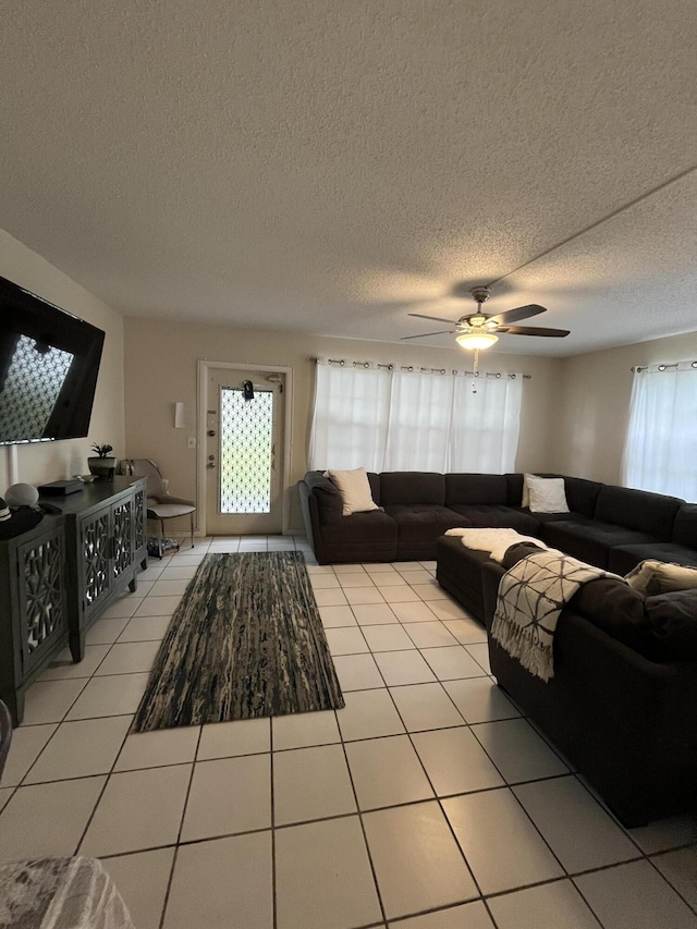 tiled living room with ceiling fan and a textured ceiling