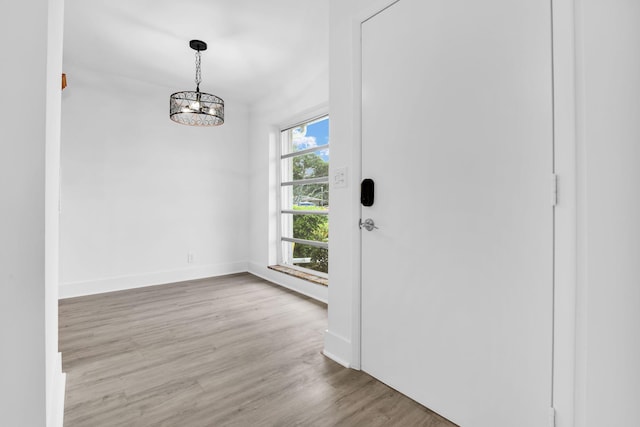 interior space with light hardwood / wood-style floors, a wealth of natural light, and a chandelier