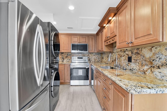 kitchen featuring light stone countertops, appliances with stainless steel finishes, decorative backsplash, and sink