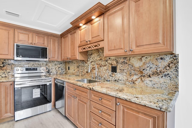 kitchen featuring stainless steel appliances, sink, tasteful backsplash, and light stone countertops