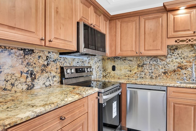 kitchen with stainless steel appliances, light stone counters, and decorative backsplash