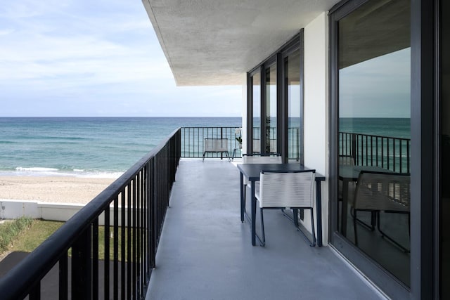 balcony featuring a water view and a view of the beach