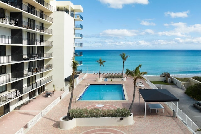 view of pool with a patio area and a water view