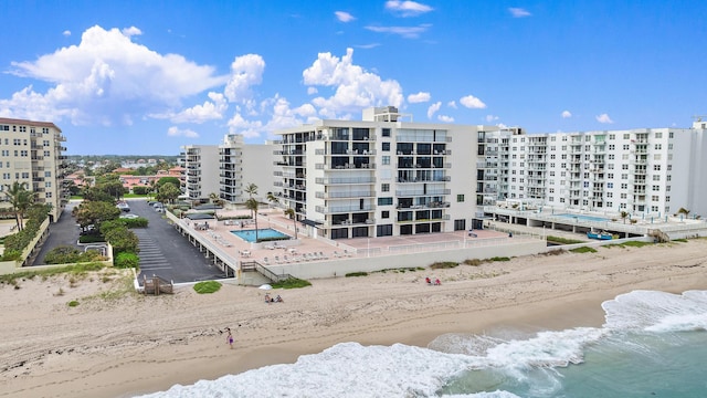 view of building exterior with a water view and a beach view