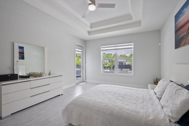 bedroom with a raised ceiling, light hardwood / wood-style floors, ceiling fan, ornamental molding, and access to outside