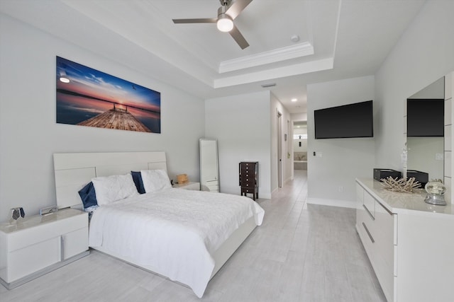 bedroom featuring ceiling fan, light wood-type flooring, crown molding, and a tray ceiling