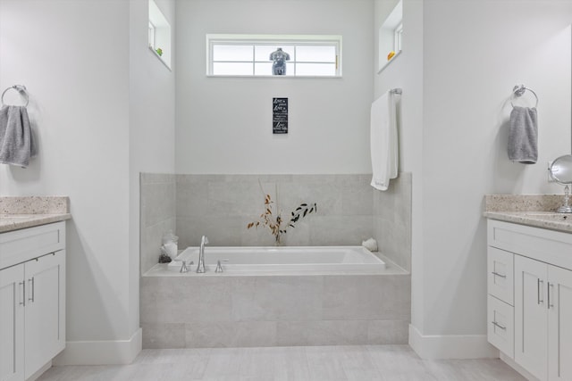 bathroom featuring tiled bath, tile patterned floors, and vanity