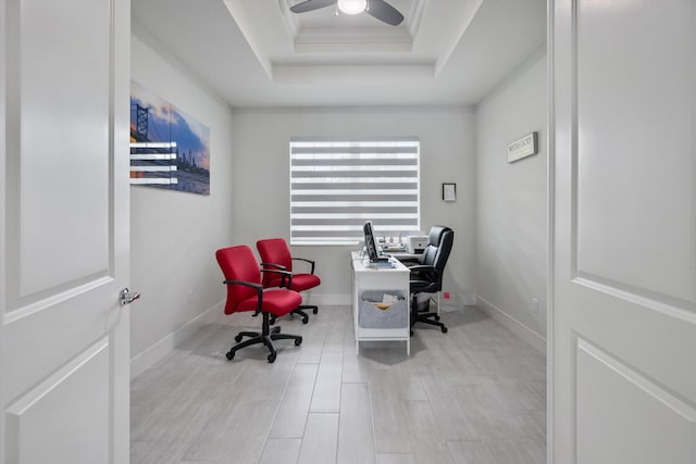 office space with ornamental molding, ceiling fan, light hardwood / wood-style flooring, and a raised ceiling