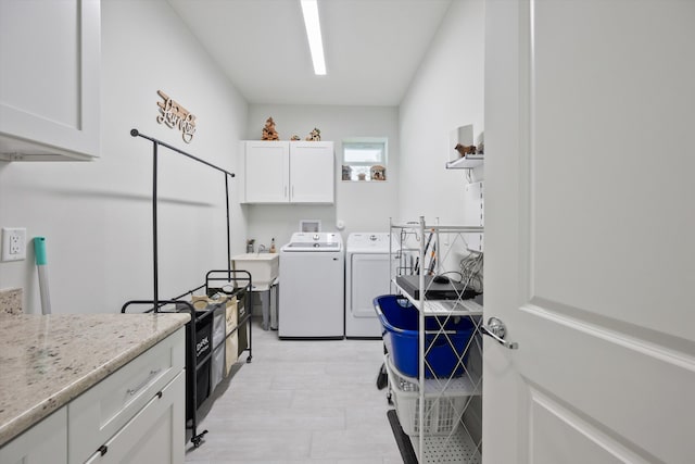 washroom featuring sink, cabinets, and washing machine and dryer