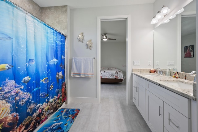 bathroom with wood-type flooring, ceiling fan, walk in shower, and vanity