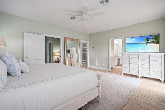 bedroom with ceiling fan, light hardwood / wood-style floors, and connected bathroom