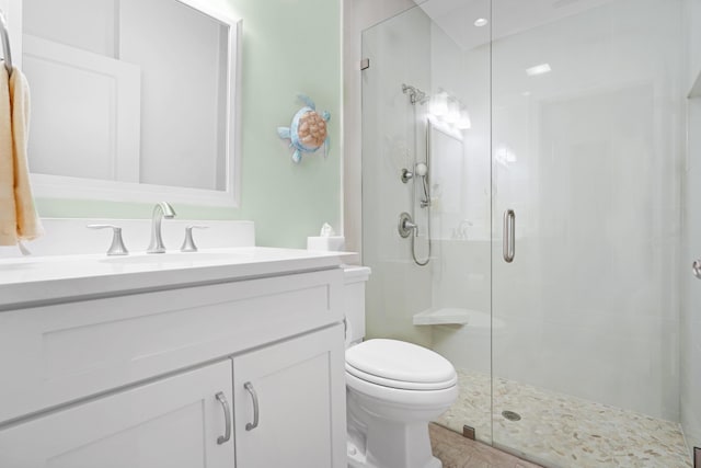 bathroom featuring vanity, an enclosed shower, and toilet