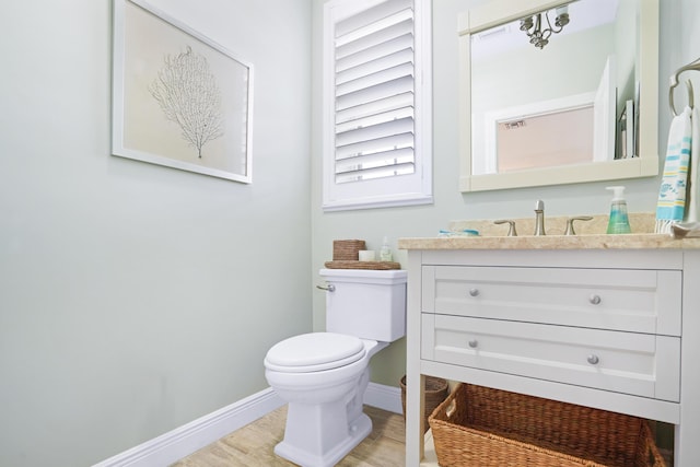 bathroom featuring hardwood / wood-style flooring, toilet, and vanity