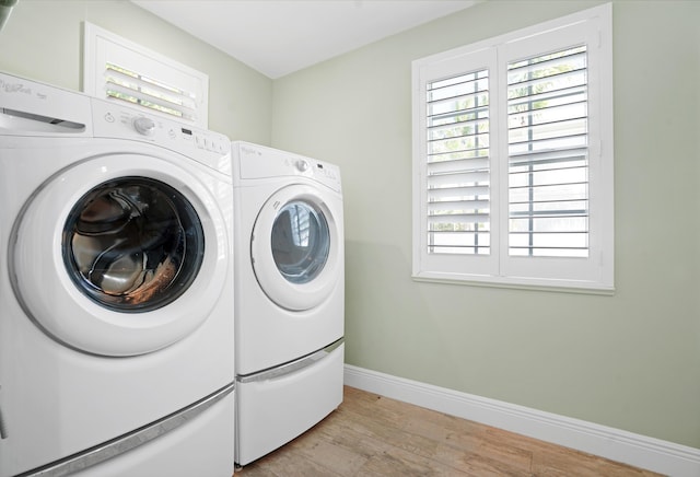 laundry room featuring independent washer and dryer and light hardwood / wood-style floors