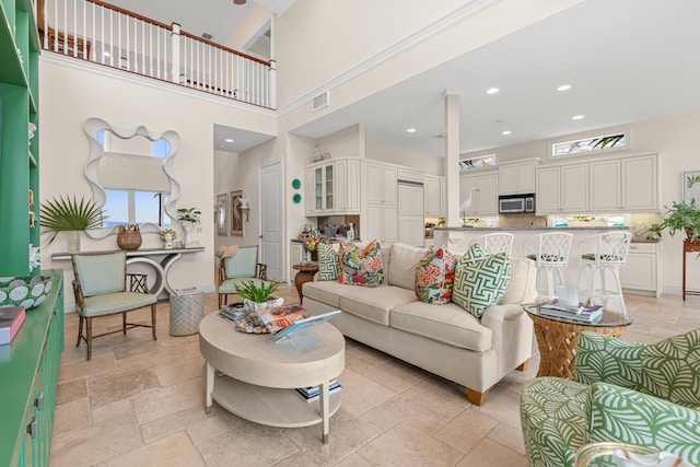 living area featuring recessed lighting, a high ceiling, visible vents, baseboards, and stone tile flooring