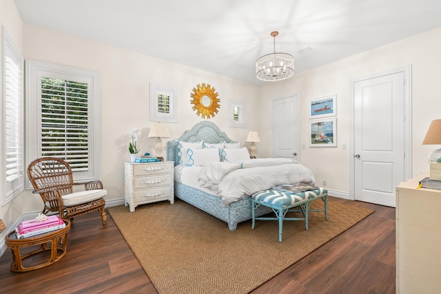 bedroom featuring an inviting chandelier, baseboards, and dark wood-style flooring