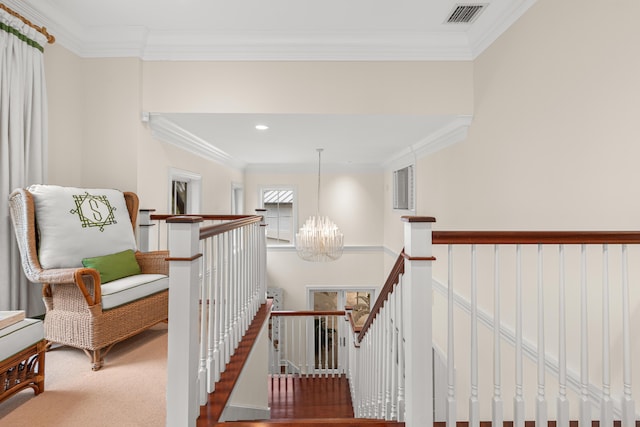 staircase featuring visible vents, crown molding, carpet flooring, and an inviting chandelier