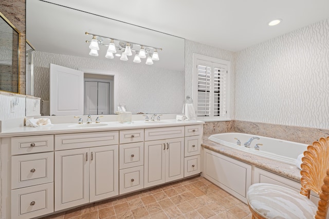 full bathroom with double vanity, a sink, a bath, and wallpapered walls