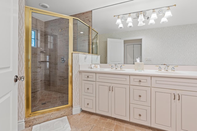 bathroom with double vanity, a stall shower, and a sink