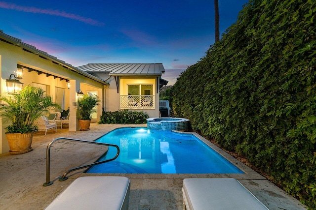 view of pool with a patio and a pool with connected hot tub