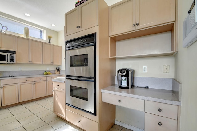 kitchen with stainless steel appliances, light brown cabinetry, and light tile patterned floors