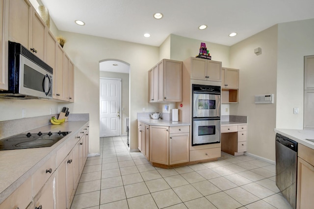 kitchen with stainless steel appliances, light brown cabinetry, and light tile patterned floors