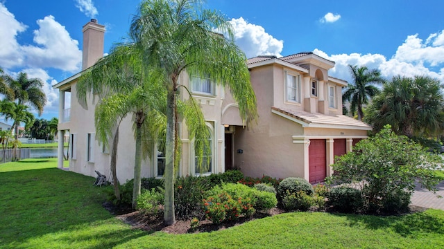 mediterranean / spanish house with a front yard and a garage