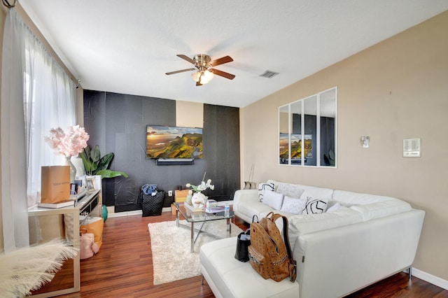 living room featuring ceiling fan and dark hardwood / wood-style floors