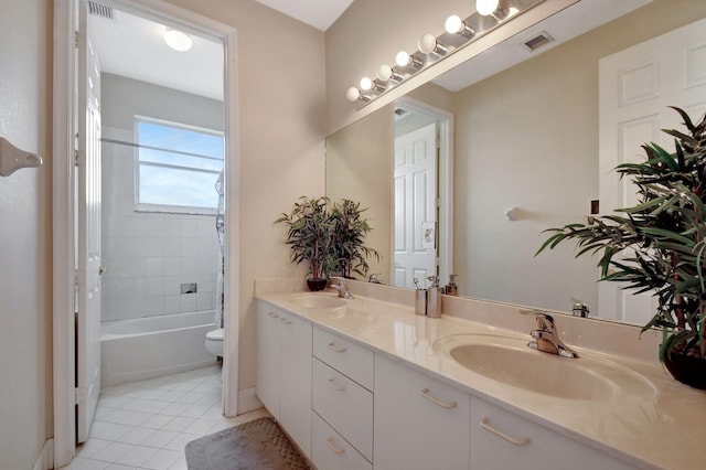 full bathroom with vanity, tile patterned flooring, tiled shower / bath combo, and toilet