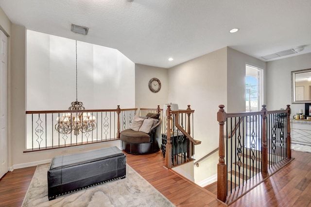 living area with an inviting chandelier and hardwood / wood-style flooring