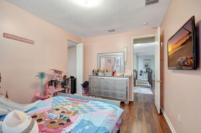 bedroom with dark hardwood / wood-style flooring and a textured ceiling