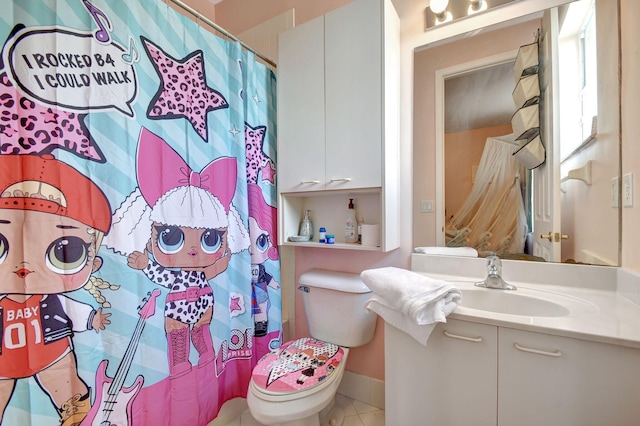 bathroom featuring toilet, vanity, tile patterned floors, and curtained shower