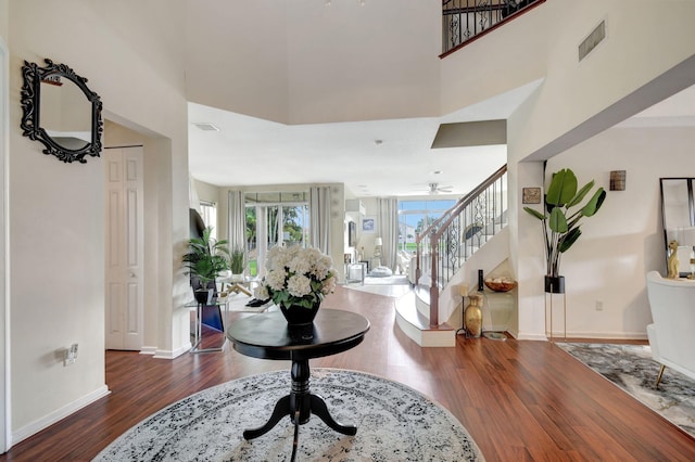 entrance foyer featuring a high ceiling, dark wood-type flooring, and ceiling fan