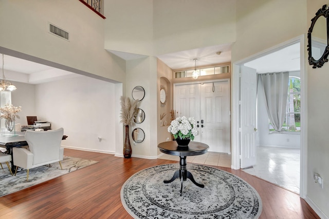 foyer with wood-type flooring and a notable chandelier