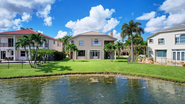 rear view of property with a yard and a water view