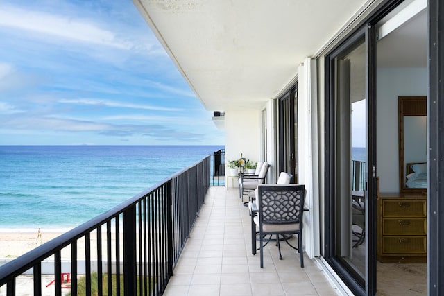 balcony featuring a water view and a view of the beach