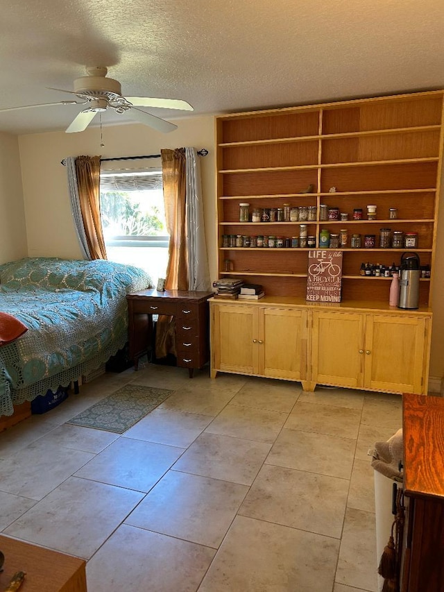 bedroom with light tile patterned flooring, ceiling fan, and a textured ceiling