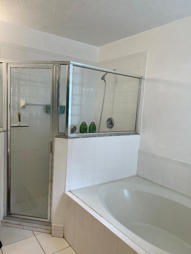 bathroom featuring tile patterned floors, independent shower and bath, and a textured ceiling