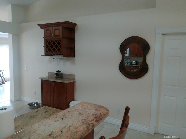 dining space featuring bar and light tile patterned floors