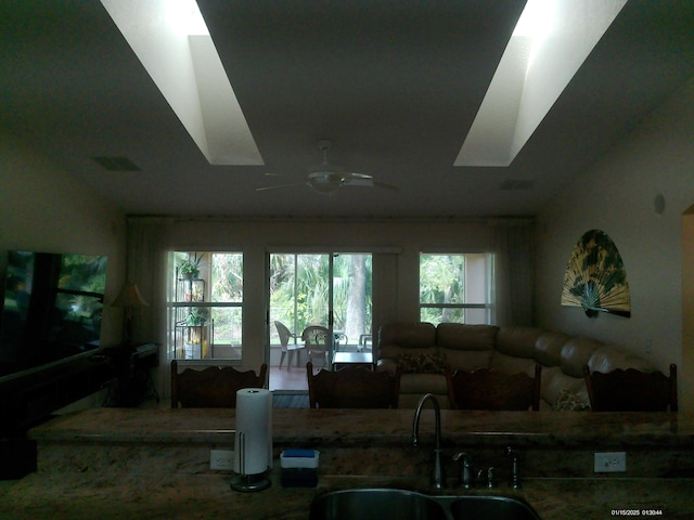 kitchen featuring vaulted ceiling, ceiling fan, and sink