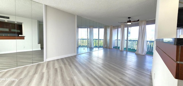 unfurnished living room with a textured ceiling, ceiling fan, and hardwood / wood-style floors