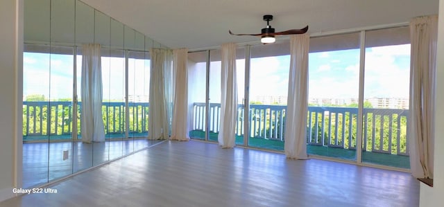 unfurnished sunroom with ceiling fan