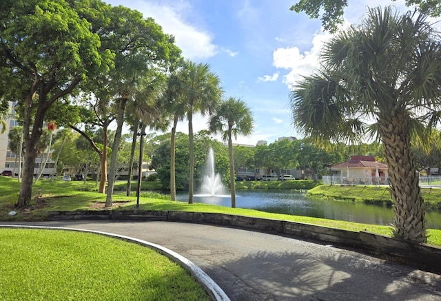 view of community with a lawn and a water view