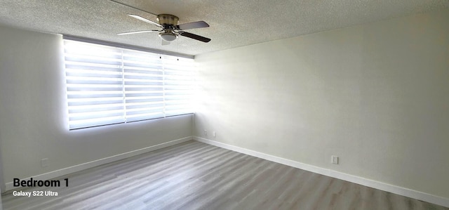 empty room featuring hardwood / wood-style flooring, a textured ceiling, and ceiling fan