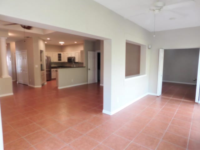 spare room featuring ceiling fan and light tile patterned floors