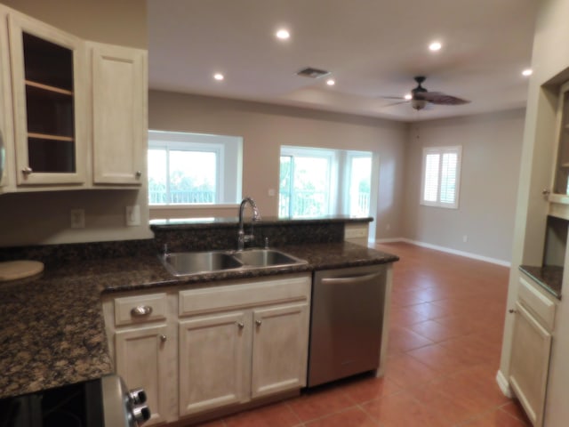 kitchen featuring sink, dishwasher, ceiling fan, light tile patterned floors, and dark stone counters