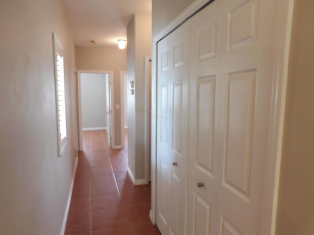 corridor featuring dark tile patterned floors and a healthy amount of sunlight