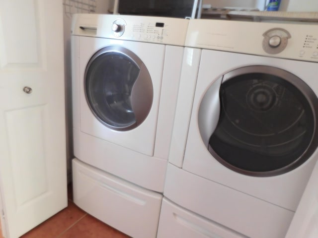 laundry area featuring washing machine and dryer and tile patterned flooring